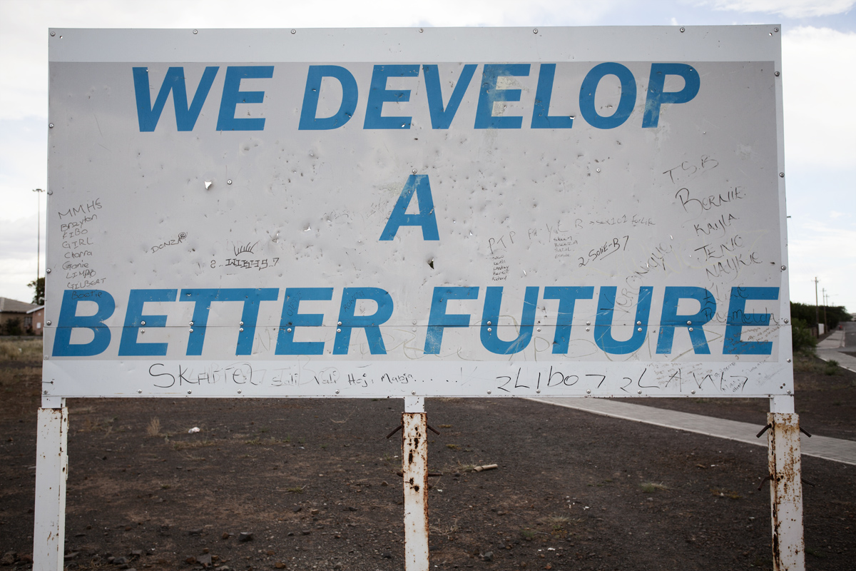 An Asla Construction sign with graffiti on it. Asla is the construction company that builds RDP houses in the Western Cape.